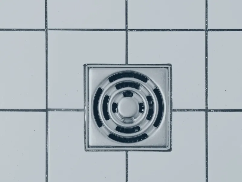 Bodenablauf einer Dusche aus Metall im Fliesenboden