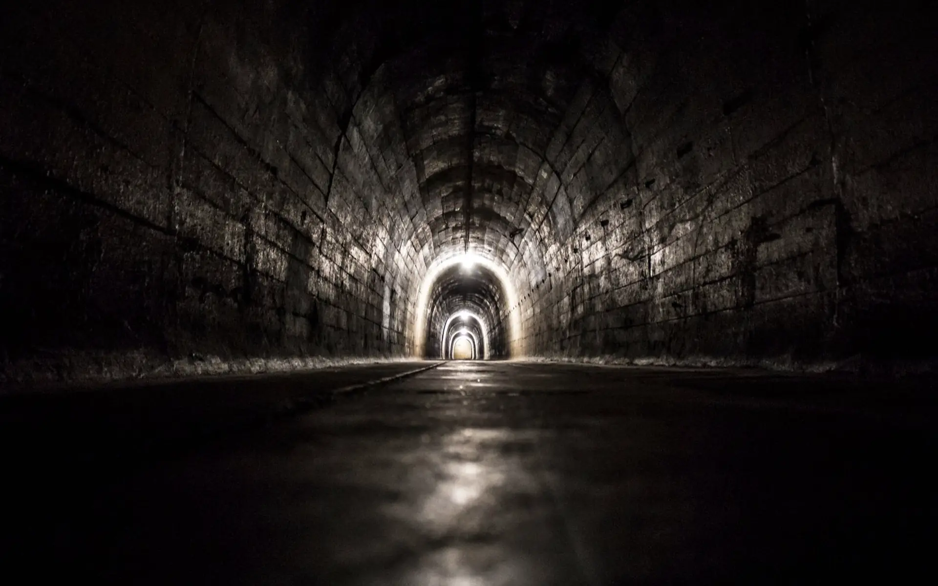Blick durch einen gemauerten Abwasserkanal auf den hellen Ausgang am anderen Ende